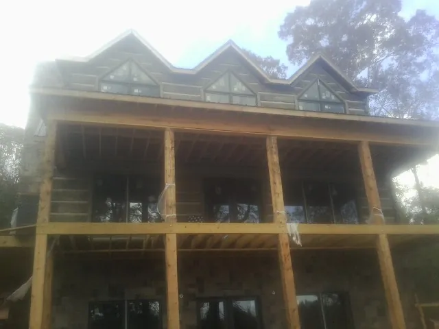 Dormers and porch framing on a large log home under construction — Roof Coating work by our crew in Marblemount